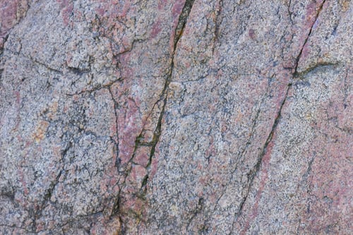 Preview: Texture Of Granite Close Up. Granite Rock With Reddish Color. Background From Solid Stone. Pattern