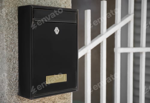 Preview: Black metal letter box on beige textured wall, closeup and space for text