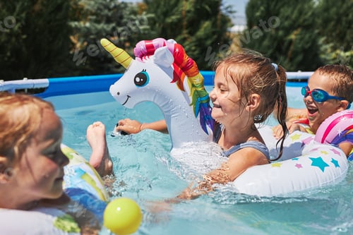 Preview: Children playing in a pool in a home garden. Kids having fun playing together on a summer sunny day