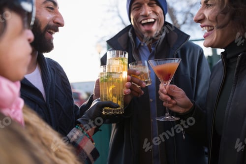Preview: Friends enjoying drinks and laughter outdoors