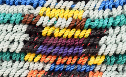 Preview: A stack of colorful woven rugs for sale