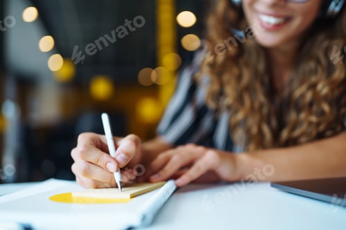Preview: Meeting online. Young woman wearing headphones using laptop watching webinar or doing video chat.