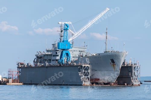 Preview: Large iron navy ships in shipyard for repair. Big crane in dockyard. Blue sea harbor