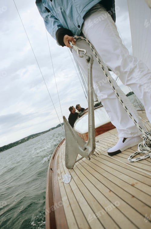 Preview: Person on deck of boat holding anchor