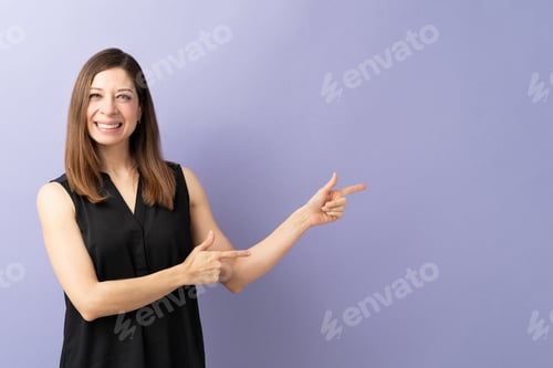 Preview: Cute woman pointing at copy space