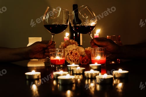 Preview: Couple toasting with red wine, candlelight, romantic date, couple in love, candles