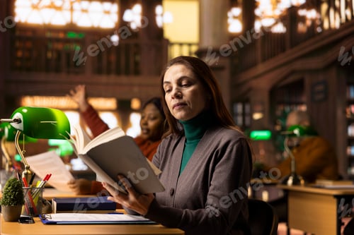 Preview: Senior woman reading a book in a study room at a public library