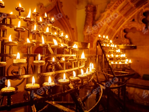 Preview: Lit candles in racks in a historic church