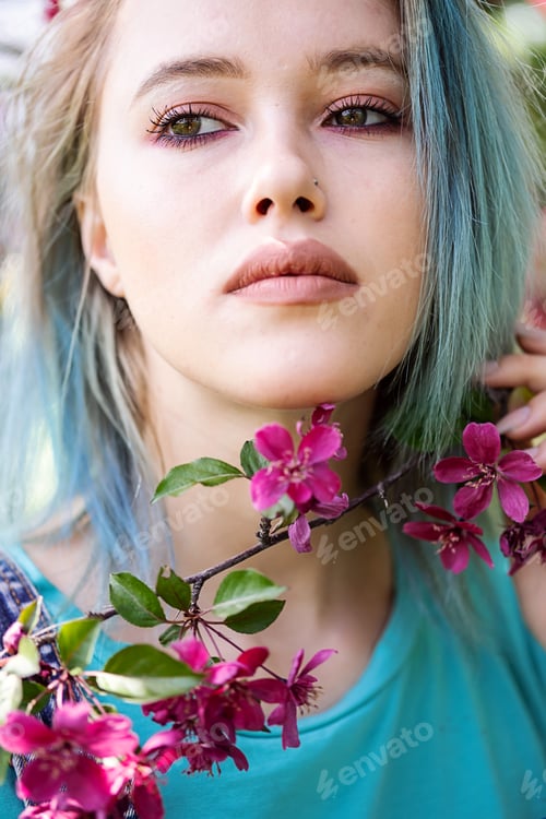 Preview: Portrait of Blue Haired Woman Against Pink Blossom Trees.