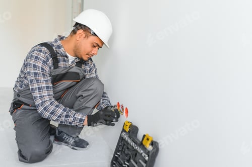 Preview: an Indian electrician installs an outlet in a new building