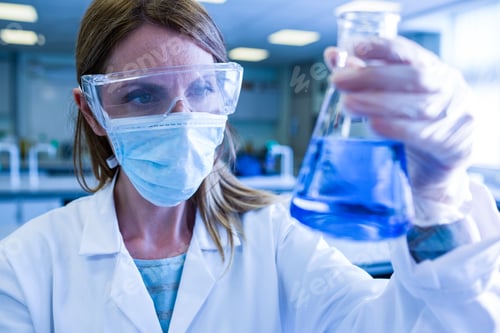 Preview: Scientist holding up beaker of chemical at the university