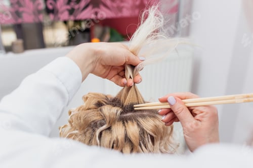 Preview: Hairdressers hands drying long blond hair with blow dryer and round brush