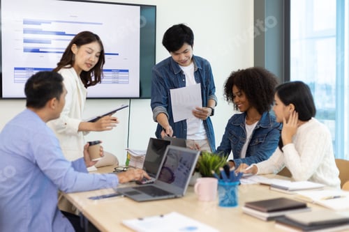 Preview: Young people meeting to discuss successful business projects in the office.