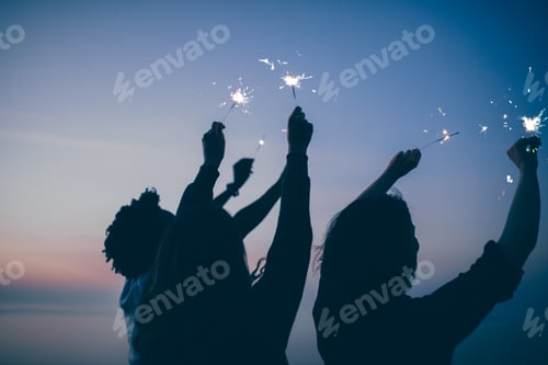 Preview: Group of friends celebrating at night with sparklers