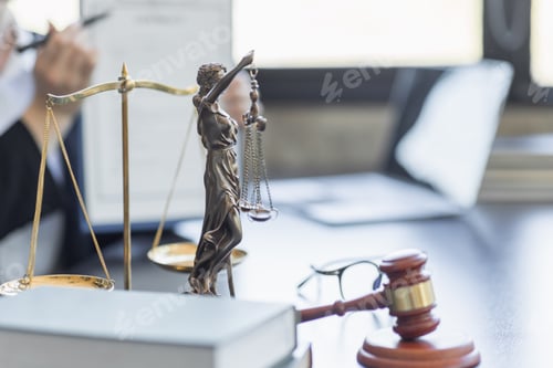 Preview: Statue of Justice and female lawyer in suit at workplace with laptop, gavel and femida in office.