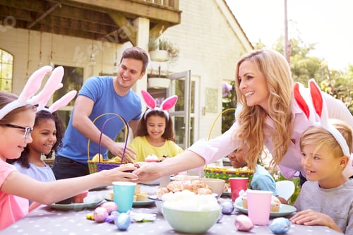 Preview: Parents With Children Wearing Bunny Ears Enjoying Outdoor Easter Party In Garden At Home