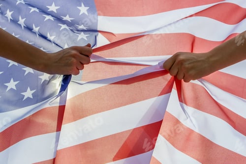 Preview: Two human hands holding USA national flag. Celebration of United States independence day concept
