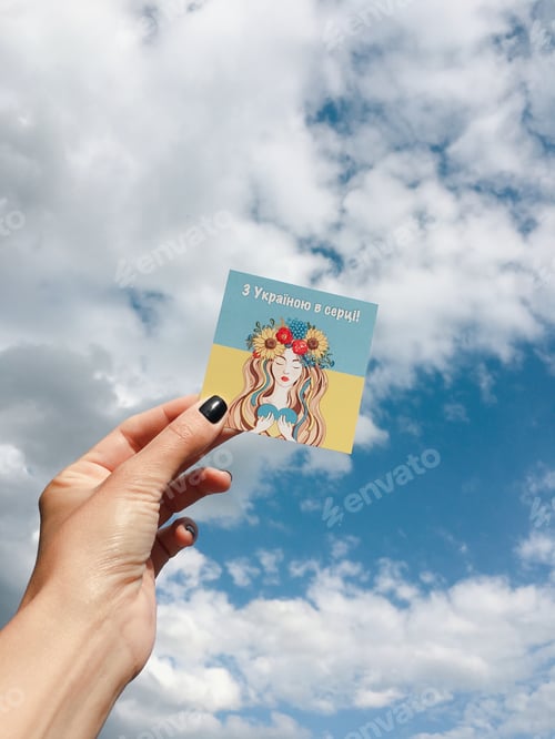 Preview: Women’s manicured hand holding a card about love of Ukraine