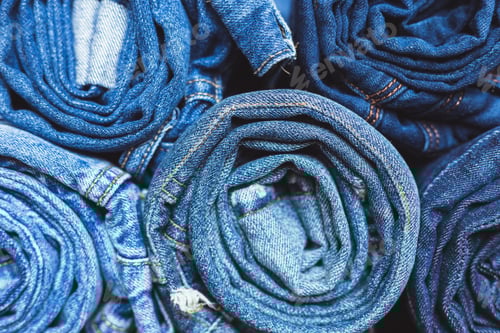 Preview: Jeans stacked on a wooden background
