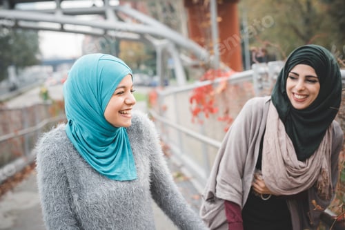 Preview: Two young female friends laughing on park path