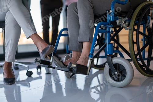 Vorschau: Verschiedene Geschäftskollegen arbeiten zusammen. Frau im Rollstuhl arbeitet im inklusiven Büro, Teamarbeit