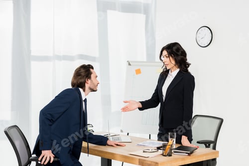 Preview: attractive recruiter gesturing while standing near man in office