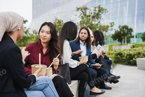 Preview: Multiethnic business people doing lunch break outdoor from office building