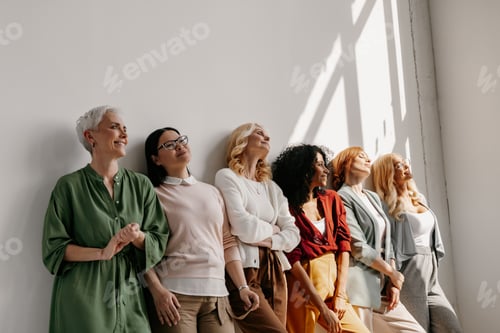 Preview: Multi-ethnic group of mature women bonding and smiling while leaning on the wall together