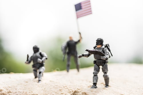 Preview: selective focus of toy soldiers with weapon and american flag on sand