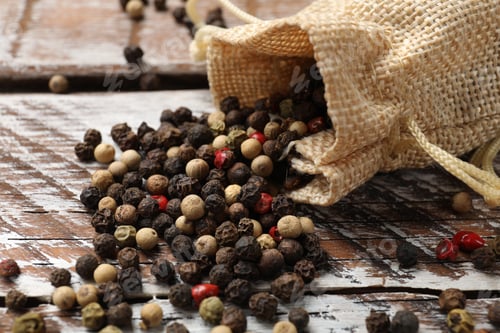 Preview: Aromatic spice. Different peppers in burlap bag on wooden table, closeup