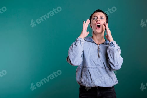 Preview: Portrait of angry unhappy woman having agressive emotion screeming while posing in studio