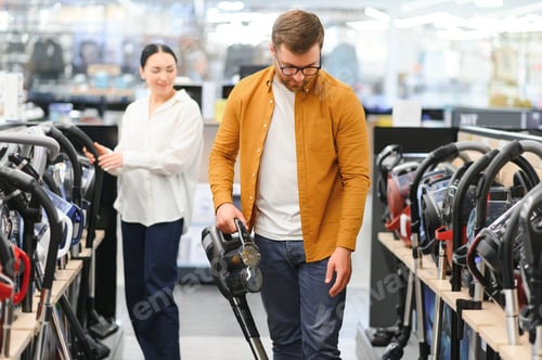 Preview: Couple choosing vacuum cleaner, electronics store