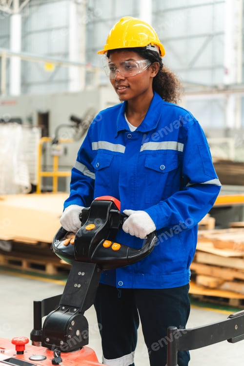 Preview: African American female worker driving forklift truck in heavy metal industrial factory
