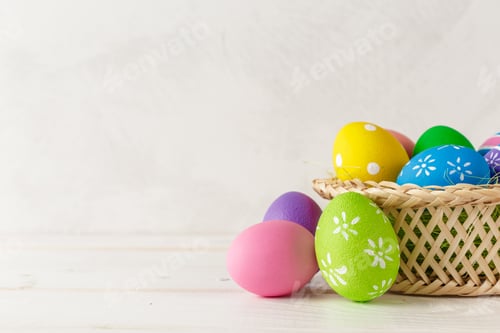 Preview: Colorful easter eggs in a basket on a table waiting for an easter celebration event