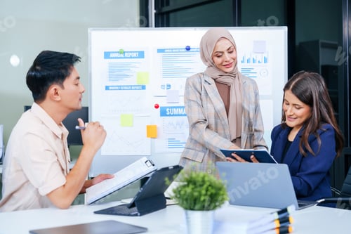 Preview: A multicultural team of professionals, including male and female businesspersons, around a desk