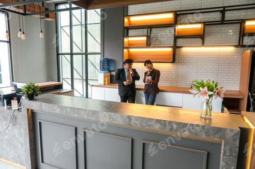 Preview: Business Colleagues Discussing Project In Modern Office Lobby