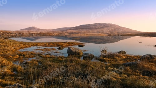 Preview: Beautiful sunrise landscape scenery of Mullaghmore mountain reflected in Lake at Burren National Par