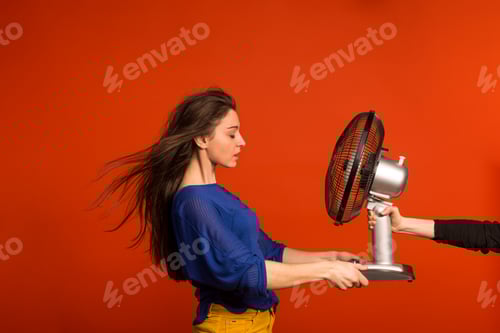 Preview: Portrait of a young beautiful woman with a fan in studio.