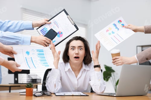 Preview: Woman overwhelmed by different requests from colleagues at desk in office