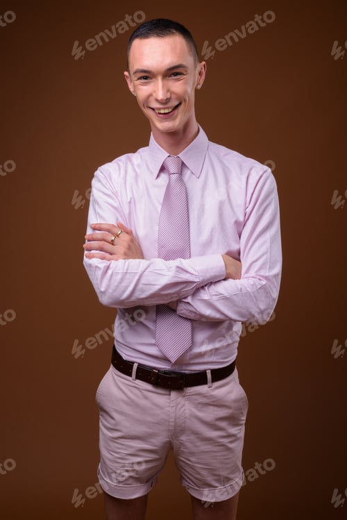 Preview: Young handsome androgynous businessman against brown background