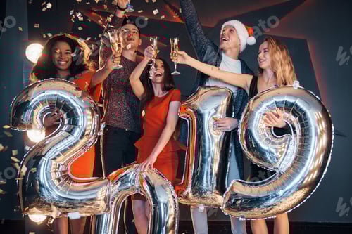 Visualização: Lindos jovens amigos, se divertindo na véspera de Ano Novo, com números para 2019