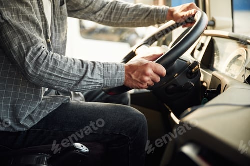 Preview: Close up view, sitting inside. Young truck driver in casual clothes