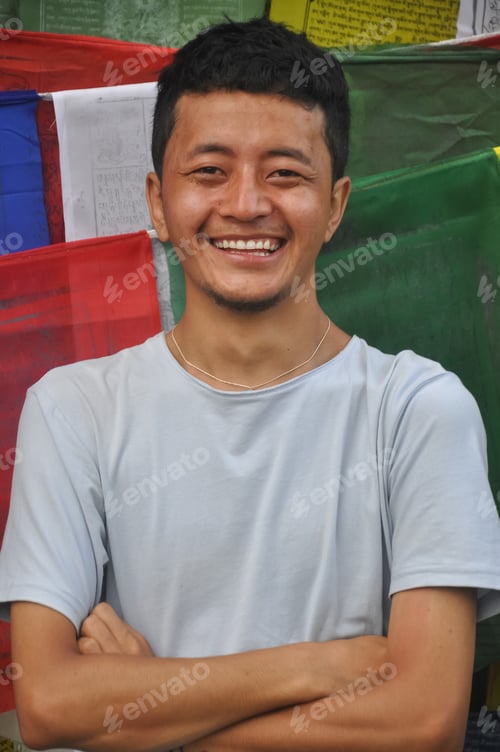 Preview: Waist up of a happy Ladakhi guy posing with crossed hands looking at camera