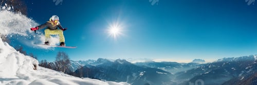 Preview: Snowboarder Jumping High in Sunny Mountain Landscape Wide Banner