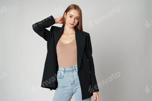 Preview: Young Woman Wearing Black Jacket and Jeans posing on gray background studio shot .