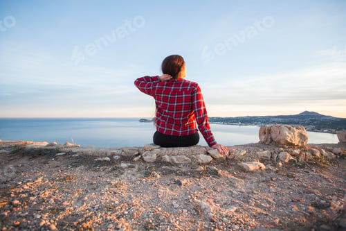 Preview: Travel, adventures and nature concept - Female tourists sitting alone on the mountain