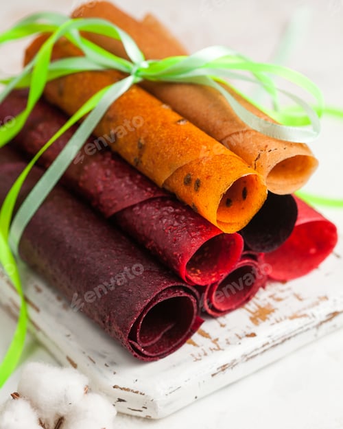 Preview: assorted apple pastilles in rolls on a light background close-up