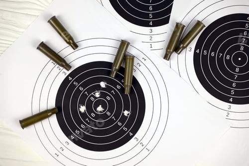 Preview: Many bullets on shooting targets on white table in shooting range polygon