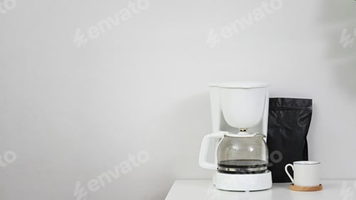 Preview: Coffee machine, coffee mug and black bag on copy space table.