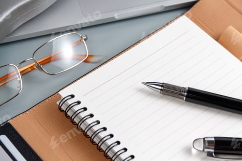 Preview: Opened agenda and pen on a grey close up